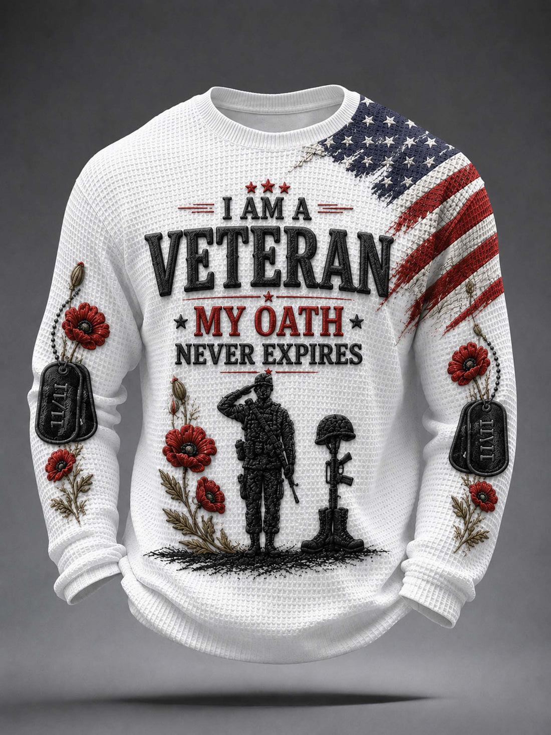 A white waffle-knit crewneck sweatshirt featuring a patriotic veteran graphic. The design includes a distressed American flag on the right shoulder, red poppy flowers, black dog tags, a soldier silhouette, a helmet, and the text 'I AM A VETERAN MY OATH NEVER EXPIRES'.