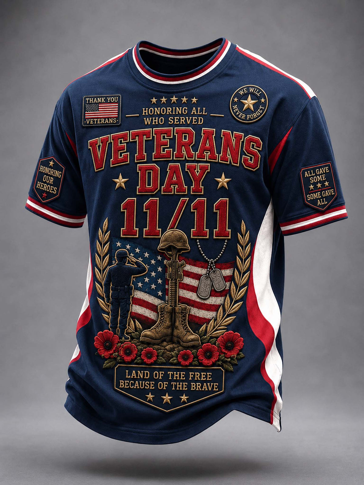 A navy blue short-sleeve t-shirt with a detailed Veterans Day 11/11 graphic on the front, featuring red and white text, a military helmet and rifle, soldiers, and an American flag. The shirt has red, white, and blue trim and graphic patches on the sleeves, shown against a neutral gray background.