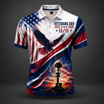 A short-sleeve polo shirt with a patriotic Veterans Day 11/11 design, featuring an American flag pattern, a bald eagle, and a military helmet on a tombstone at sunset, shown on a dark gray background.