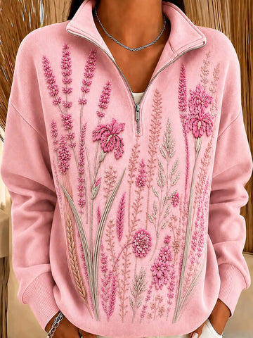 A pink quarter-zip sweatshirt featuring detailed floral embroidery across the front, shown on a model.