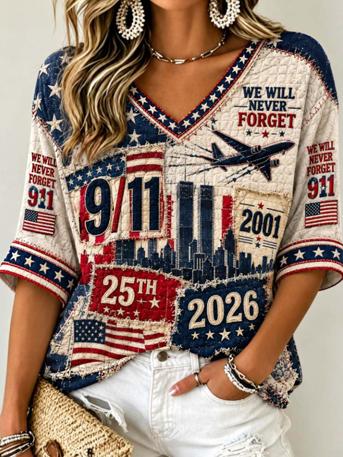 A woman wearing a patriotic-themed short-sleeve V-neck t-shirt with a distressed patchwork design featuring American flags, the 9/11 towers, the year 2001, and '25th 2026'.