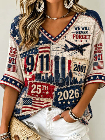 A woman wearing a patriotic-themed short-sleeve V-neck t-shirt with a distressed patchwork design featuring American flags, the 9/11 towers, the year 2001, and '25th 2026'.