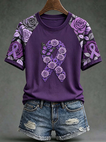A purple short-sleeve raglan T-shirt with a large purple rose and ribbon graphic on the front, styled with distressed denim shorts on a hanger against a dark gray background.
