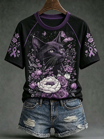 A black short-sleeve raglan T-shirt with a purple and black cat graphic surrounded by purple flowers, ribbons, and butterflies, styled with distressed denim shorts on a hanger against a dark gray background.