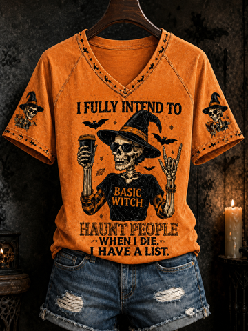 An orange short-sleeve V-neck T-shirt with a distressed Halloween graphic of a skeleton witch holding a mug, surrounded by bats and the text 'I FULLY INTEND TO HAUNT PEOPLE WHEN I DIE I HAVE A LIST.' The shirt is displayed on a hanger over distressed denim shorts against a dark, moody background with a lit candle.