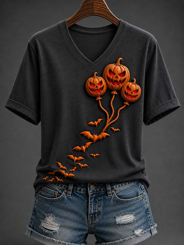 A dark charcoal gray V-neck t-shirt with a 3D-effect graphic of three glowing jack-o'-lantern balloons and flying bats, styled on a wooden hanger with distressed denim shorts against a dark gray background.