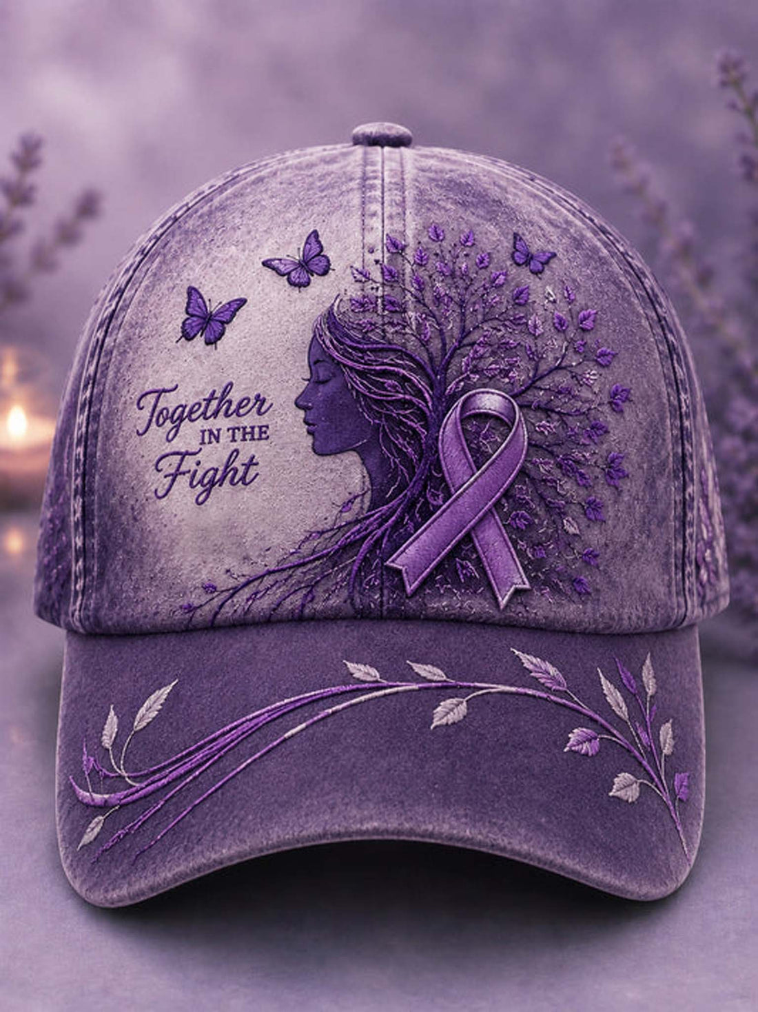 A purple distressed baseball cap featuring a side-profile illustration of a woman whose hair forms a tree with purple leaves and a matching awareness ribbon. The cap includes the text 'Together in the Fight' along with butterflies and floral embroidery on the brim, set against a soft blurred lavender background.