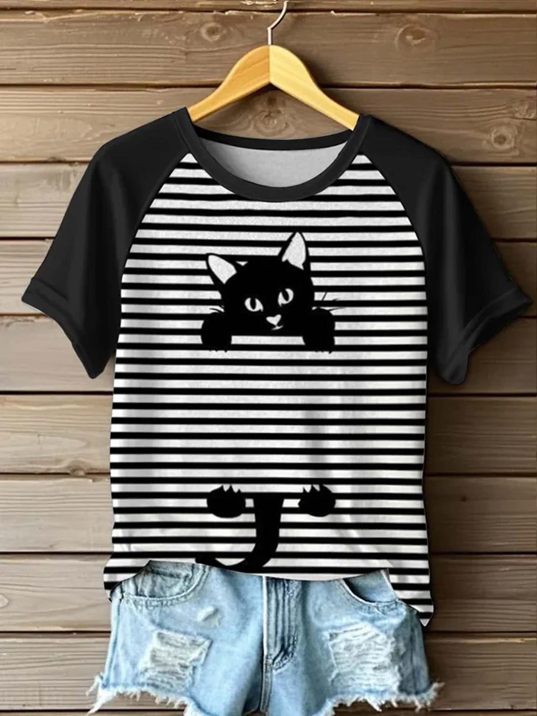 Black and white striped t-shirt with cat design on a wooden background