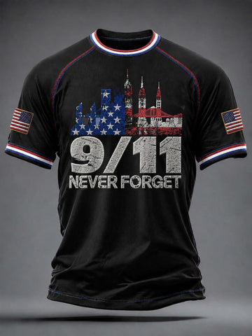 A black short-sleeve t-shirt with a distressed patriotic graphic on the front featuring the New York City skyline, the text '9/11 NEVER FORGET', and American flags on both sleeves, shown against a dark gray background.