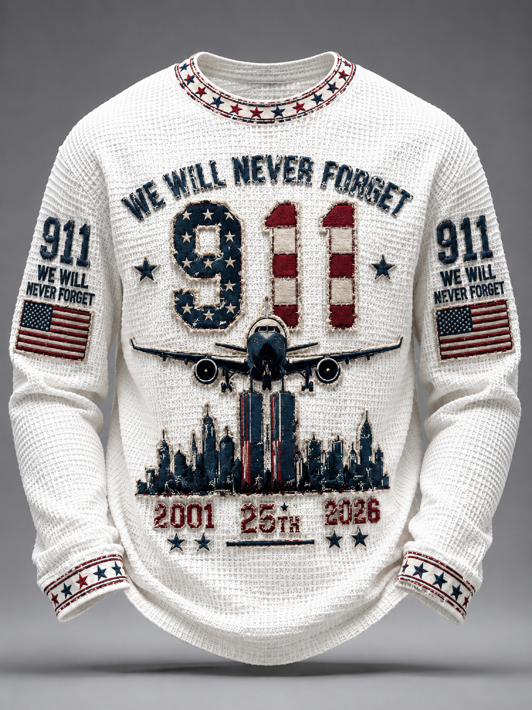 A white waffle-knit crewneck sweater with patriotic 911 first responders theme. The front features a large '911' filled with an American flag pattern, a silhouette of an airplane flying over a city skyline, and the text 'WE WILL NEVER FORGET' above.