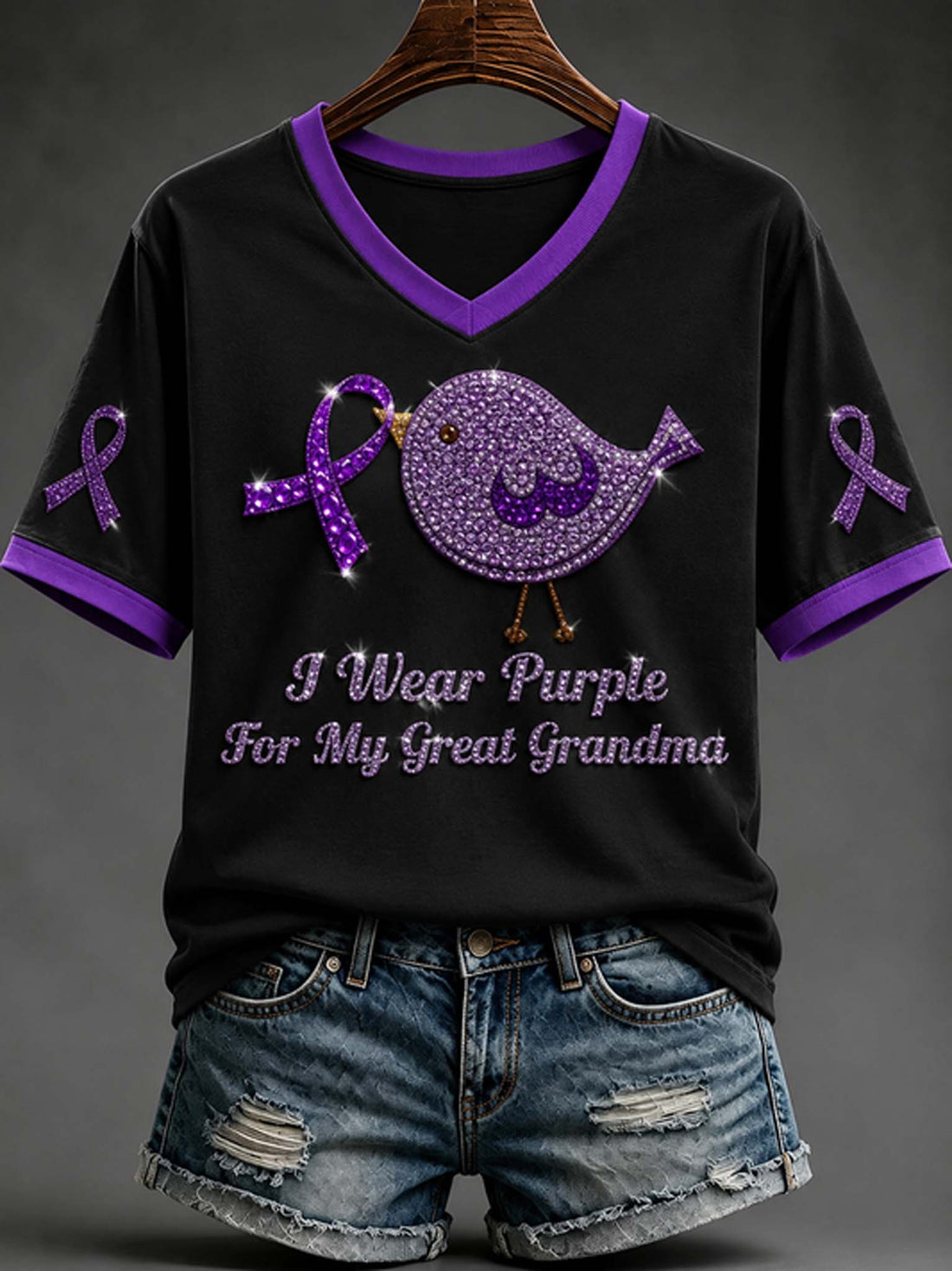 Women's black V-neck t-shirt with purple trim, purple awareness ribbon, rhinestone bird graphic, and "I Wear Purple For My Great Grandma" text paired with denim shorts.