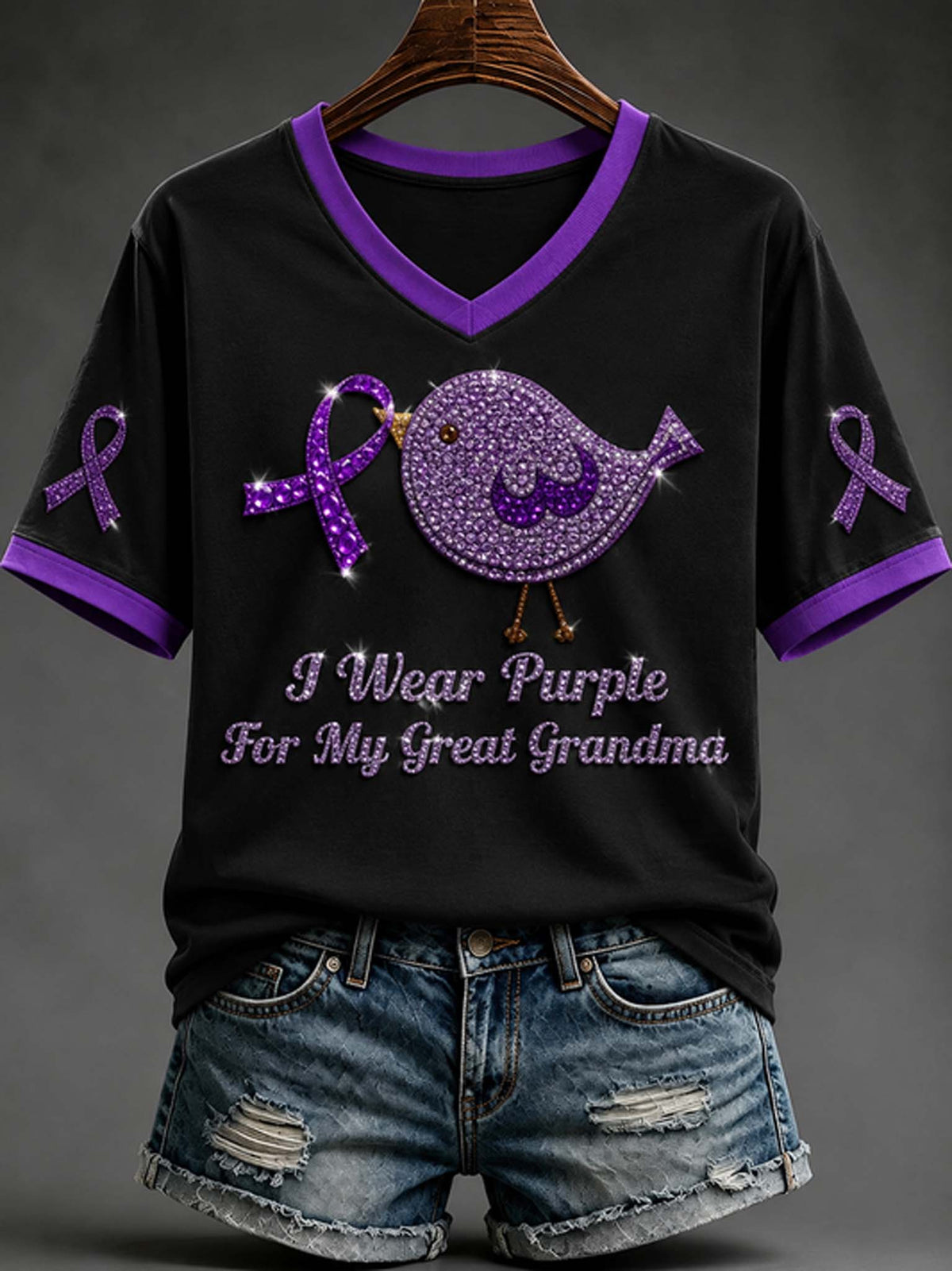 Women's black V-neck t-shirt with purple trim, purple awareness ribbon, rhinestone bird graphic, and "I Wear Purple For My Great Grandma" text paired with denim shorts.